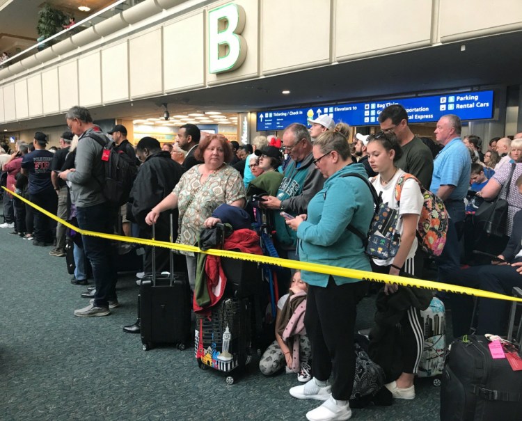 People wait to get through security at the Orlando International Airport following the death of a man who jumped from a balcony. Passengers on shuttles to gates at Florida's busiest airport had to be brought back for a second screening, bringing security checkpoints to a temporary standstill.  .  