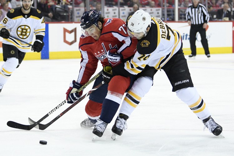 Washington right wing T.J. Oshie battles for the puck against Bruins left wing Jake DeBrusk during the second period of Boston's 1-0 win Sunday in Washington.