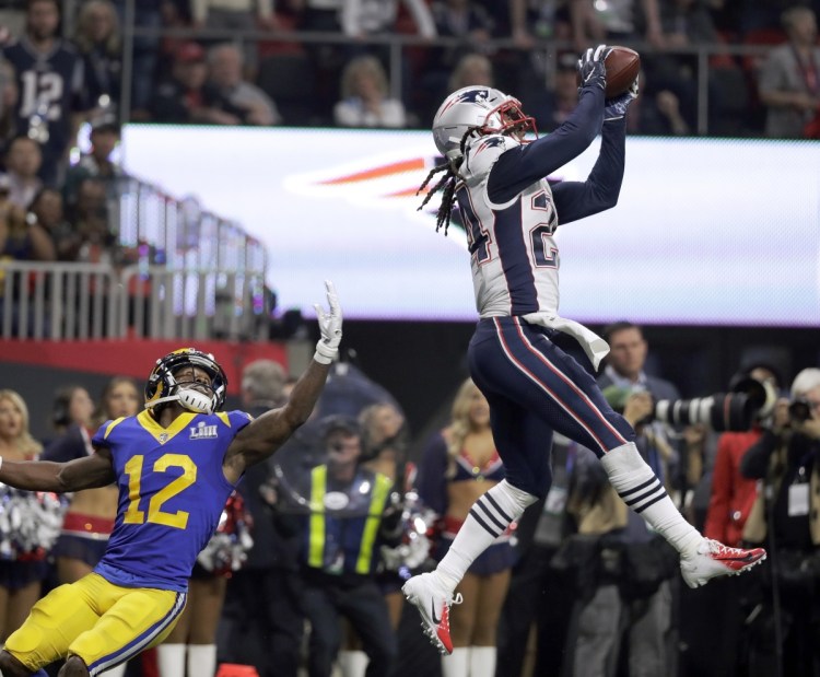 Patriots cornerback Stephon Gilmore intercepts a pass intended for Brandin Cooks of the Rams in the fourth quarter of the Super Bowl. The interception highlighted an outstanding defensive performance by the Patriots in a 13-3 victory.