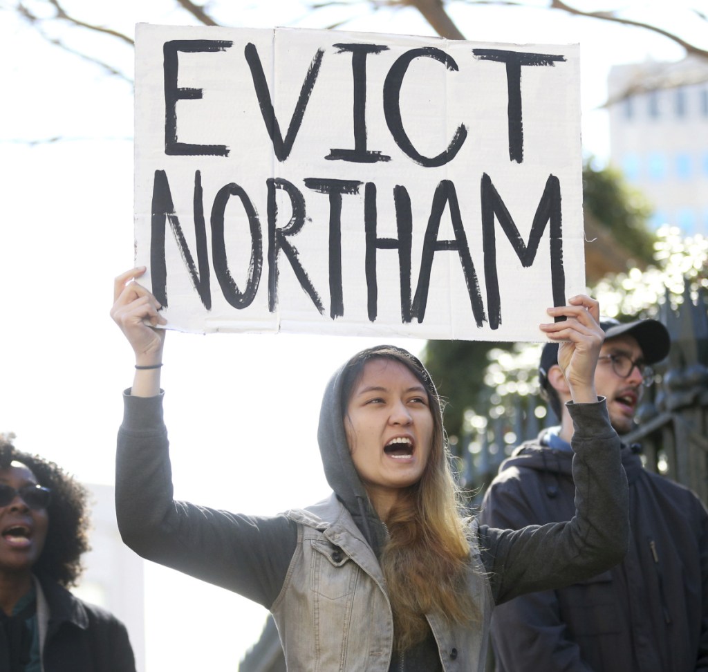 Geraldine Mabagos holds a sign during a protest in Richmond calling for Gov. Ralph Northam to resign on Monday. Northam has rebuffed widespread calls for his resignation after a racist photo surfaced Friday in his 1984 medical school yearbook page.