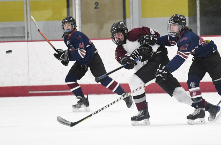 Peter Richards of Gorham drives the puck up the ice Tuesday in front of Jordan Cantz of Windham/Westbrook during Gorham's 9-1 victory. The Rams improved to 7-5 and dropped Windham to 1-10.