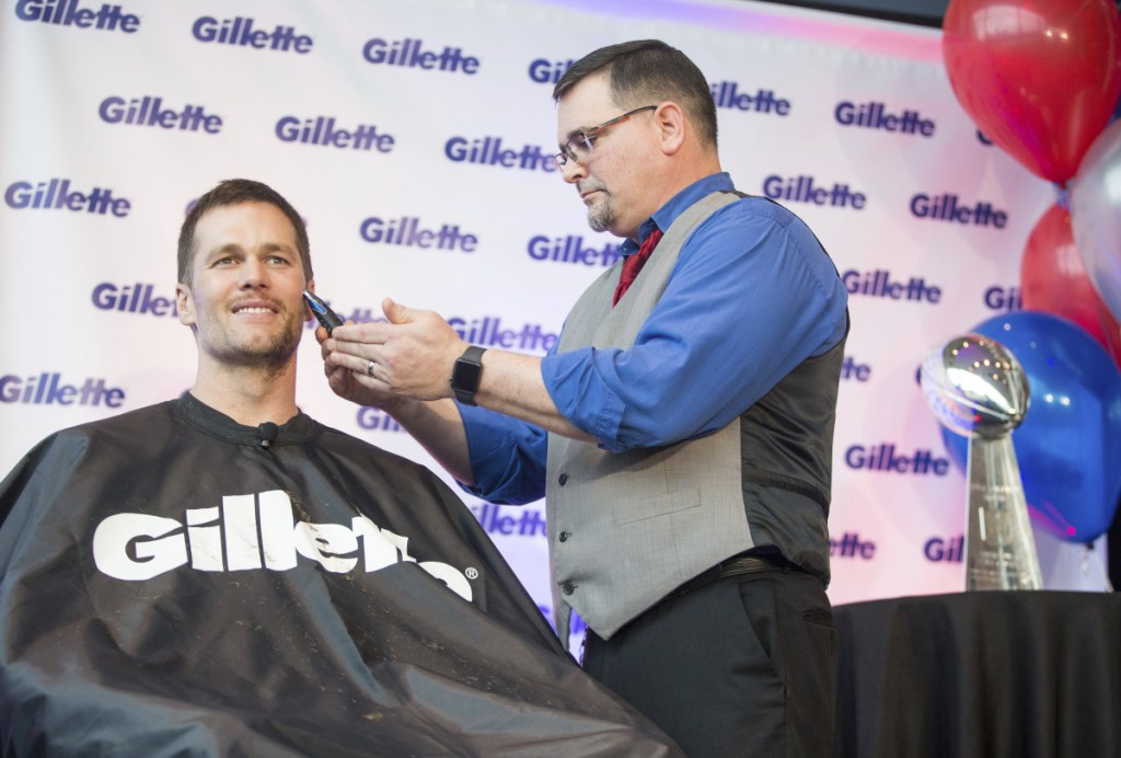 New England Patriots quarterback Tom Brady parted with his playoff stubble and signed Gillette razors to benefit charities on Thursday.