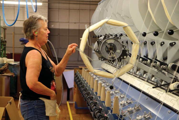 Inside Jagger Brothers worsted mill in Springvale, Ansie Stuart tends the machine that spins a hank of yarn onto a cone in 2016. Owner David Jagger said Friday that the manufacturing division will cease operations, likely by the end of March.