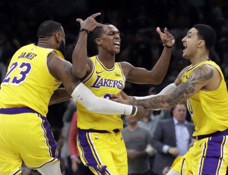 Rajon Rondo of the Los Angeles Lakers, center, celebrates with LeBron James, left, and Kyle Kuzma after hitting a winning shot Thursday night against Boston.