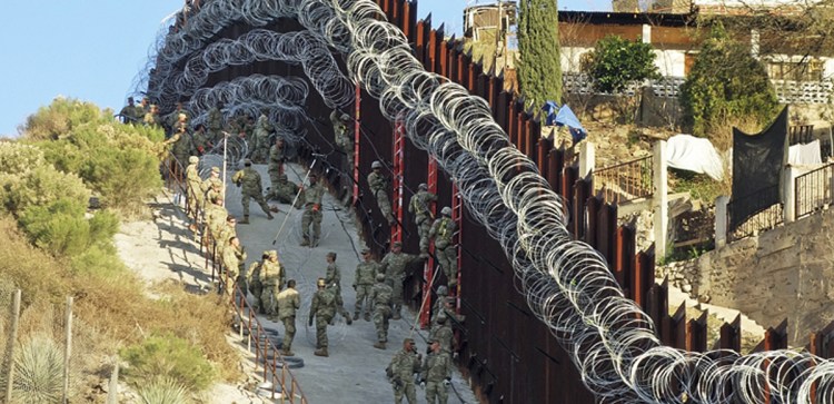 U.S. troops add concertina wire to the border fence in downtown Nogales, Ariz., on Feb. 2. Crime is down in border cities, as are estimates of the number of people entering the U.S. illegally.