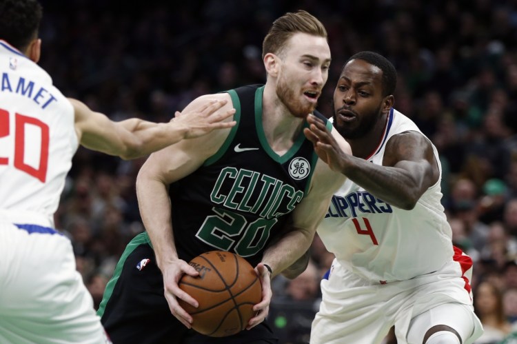 Boston Celtics' Gordon Hayward (20) drives between Los Angeles Clippers' Landry Shamet, left, and Milos Teodosic (4) during the first half of an NBA basketball game in Boston, Saturday, Feb. 9, 2019. (AP Photo/Michael Dwyer)