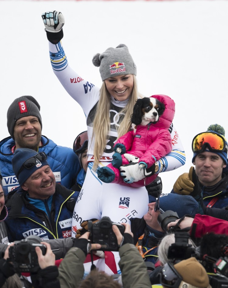 Lindsey Vonn celebrates with her dog, Lucy, after finishing with a bronze medal in the women's World Cup downhill Sunday at Are, Sweden. This was the final race of Vonn's incredible career.