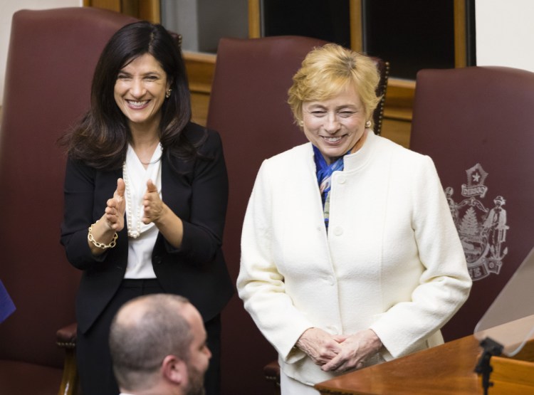 Gov. Janet Mills receives applause from supporters including House Speaker Sara Gideon, left, after her budget address to the Legislature on Monday evening.