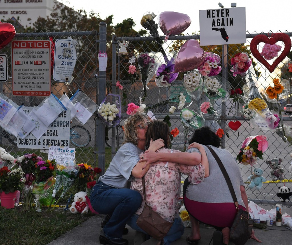 People grieve last February after a shooting at a Florida high school left 17 dead. Some students will do service work Thursday to observe the anniversary. Washington Post/Matt McClain