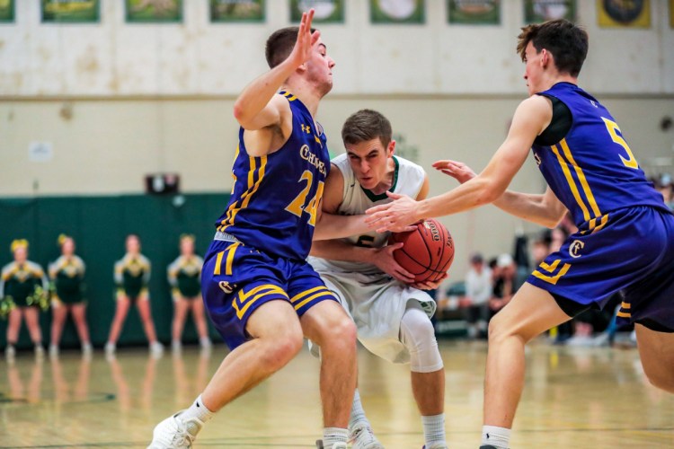 Garrett Record of Oxford Hills tries to squeeze between Patrick Foster, left, and Owen Burke of Cheverus during their Class AA North basketball quarterfinal Wednesday night. Oxford Hills won, 71-58.