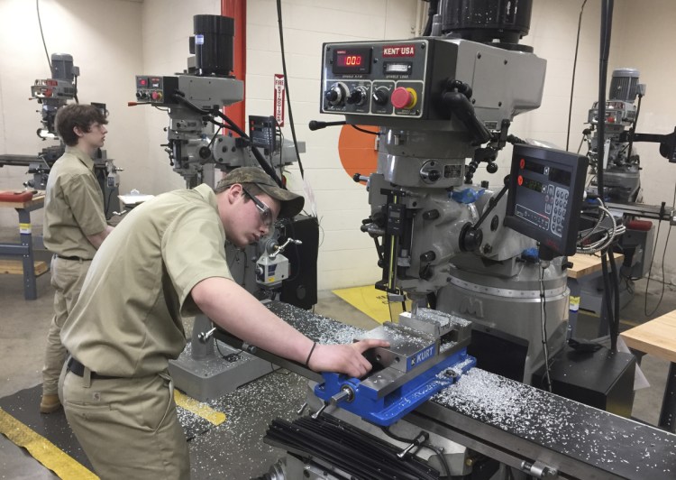 Cameron Etheridge, 18, of Dexter checks his work on a precision milling machine Thursday at SMCC.