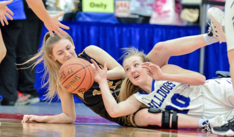 Mackenzie Bickmore, left, of Medomak Valley and Keagan Alley of Lawrence dive for a loose ball Friday afternoon during a Class A North basketball quarterfinal at the Augusta Civic Center. Lawrence won, 57-33.