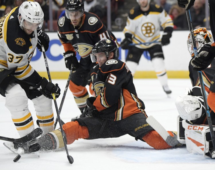 Anaheim right wing Jakob Silfverberg tries to stop a shot by Boston center Patrice Bergeron during the third period Friday night. The Bruins won 3-0.