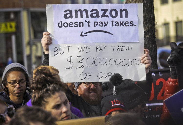 Protesters hold up anti-Amazon signs during a coalition rally and press conference of elected officials, community organizations and unions opposing Amazon headquarters getting subsidies to locate in Long Island City, in New York, on Nov. 14. Local resistance to the online retailer building part of its headquarters in Long Island City was almost immediate. The deal dissolved on Thursday.