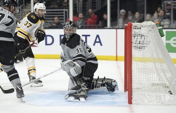 Boston center Patrice Bergeron scores on Kings goaltender Jack Campbell as center Jeff Carter watches during the third period in Los Angeles. The Bruins won 4-2.