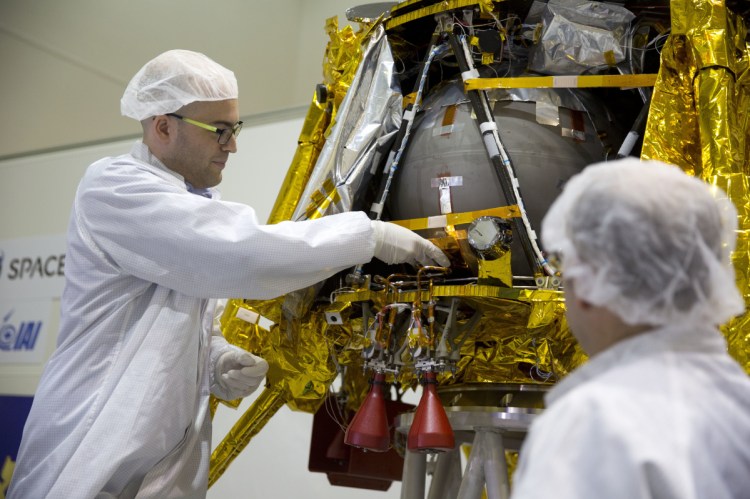 SpaceIL co-founder Yonatan Winetraub, left, inserts a time capsule into a lunar module, an unmanned spacecraft, near Tel Aviv, Israel. A SpaceX Falcon 9 will launch Thursday night with Israel's "immortal milestone" lunar lander in tow.