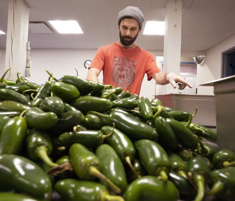 Henry Ginsberg stems jalapeño peppers for Spruced Up hot sauce.