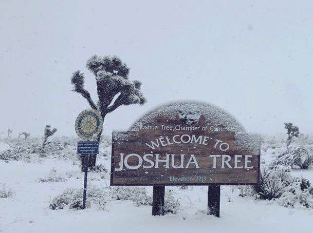 Snow sticks to the entrance sign to Joshua Tree National Park on Thursday. A cold weather system brought snow to extremely low elevations of Southern California and the San Joaquin Valley.