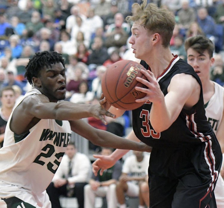 Tim Cookson of Hall-Dale attempts to keep the ball from Diraige Dahia of  Waynflete during Hall-Dale's 65-58 victory in a Class C South semifinal Thursday night as the Augusta Civic Center.