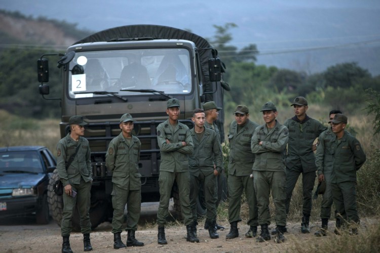 Soldiers stand at the entrance of the Tienditas International bridge that connects Venezuela with Colombia, in Urena, Venezuela, Thursday, Feb. 21, 2019. As a showdown looms over U.S.-supplied humanitarian aid destined for Venezuela, much of it warehoused near the Tienditas International bridge, President Nicolas Maduro closed off his country's border with Brazil, vowing on Thursday to block the emergency food and medicine that has rallied his opponents and which he claims is part of a U.S.-led coup plot. (AP Photo/Rodrigo Abd)