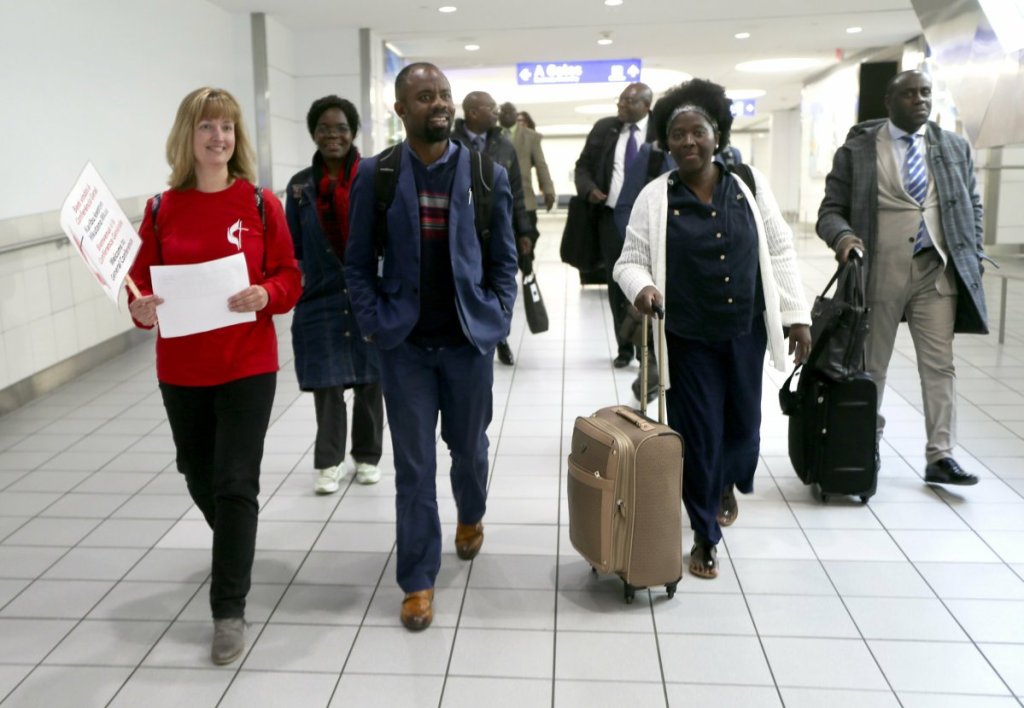 Methodist convention volunteer Kim Mertz of Chesterfield walks with The Rev. Quelende Andriano, center, and Rev. Dr. Elvira Cazombo, both of Angola, to the check-in table, as she welcomes delegates from African nations upon arrival Thursday, Feb. 21, 2019, at St. Louis Lambert International Airport. Andriano and Cazombo are among United Methodists in town to attend a special session to address homosexuality in the church. (Laurie Skrivan/St. Louis Post-Dispatch via AP)