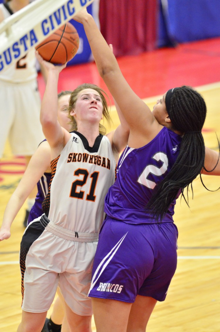 Hampden Academy's Bailey Donovan, right, blocks a shot by Annie Cooke of Skowhegan during the Class A North final Friday at the Augusta Civic Center. Hampden won, 32-28.