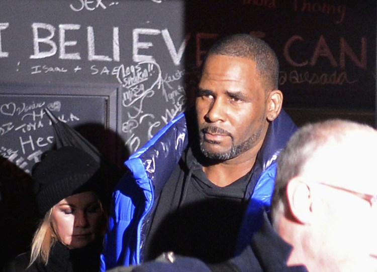 Singer-songwriter R. Kelly leaves his Chicago studio Friday night on his way to surrender to police. He has been trailed for decades by allegations that he violated underage girls and women and held some as virtual slaves.