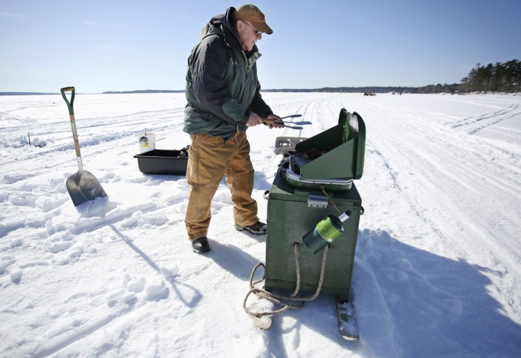 Jim Nagle of Connecticut has his grill mounted on a wooden chest, which attached to an old pair of skis and made for an easy transport at the Sebago Lake Rotary Ice Fishing Derby.