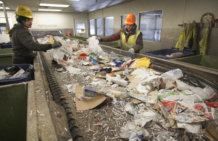 Hector Reinos, left, and Arturo Santos separate plastic and paper at ecomaine in Portland. Rep. Nicole Grohoski, D-Ellsworth, wants to ban single-use plastic bags at the point of sale in retail stores, with exemptions for those used in pharmacies, or for produce and meat. 