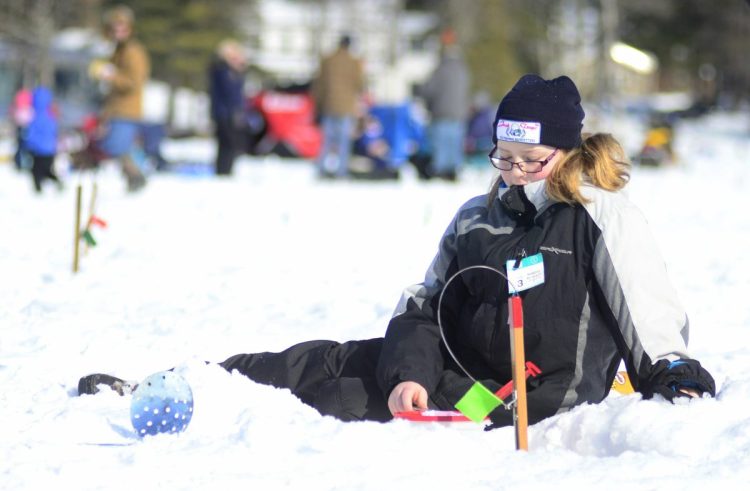 Danyka Blundon, 10, of Monmouth, sits on the ice while keeping a close eye on her trap during the Jack Traps children's ice fishing derby Saturday on Cochnewagon Lake in Monmouth.