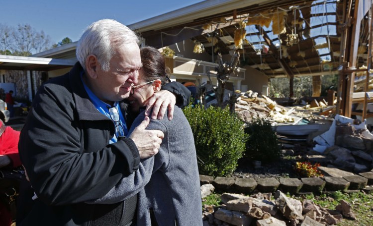 Pastor Steve Blaylock comforts his wife, Pat, amid the rubble that was once the First Pentecostal Church in Columbus, Miss., Sunday. A tornado Saturday wrecked havoc in the community, destroying a number of businesses and homes.