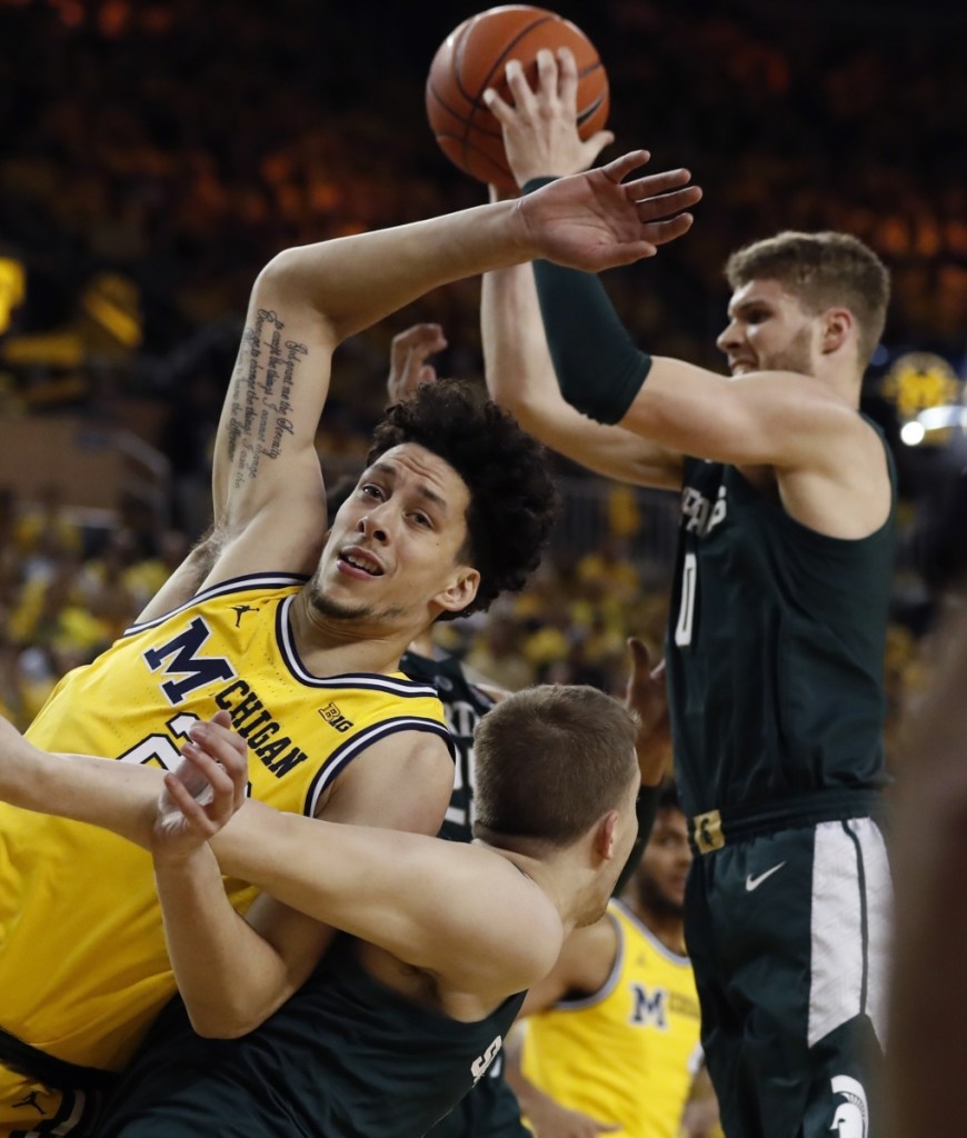 Michigan State forward Kyle Ahrens grabs a rebound next to Michigan forward Brandon Johns Jr. during the first half of the No. 10 Spartans' 77-70 win over the seventh-ranked Wolverines at Ann Arbor.