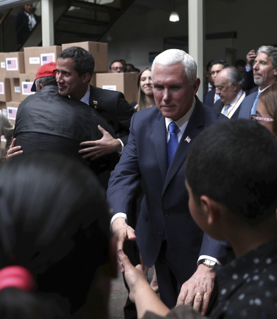 Vice President Mike Pence, right, and Venezuela's self-proclaimed interim president Juan Guaido, left rear, meet Venezuelan citizens Monday after attending a meeting of the Lima Group concerning Venezuela at the Foreign Ministry in Bogota, Colombia.