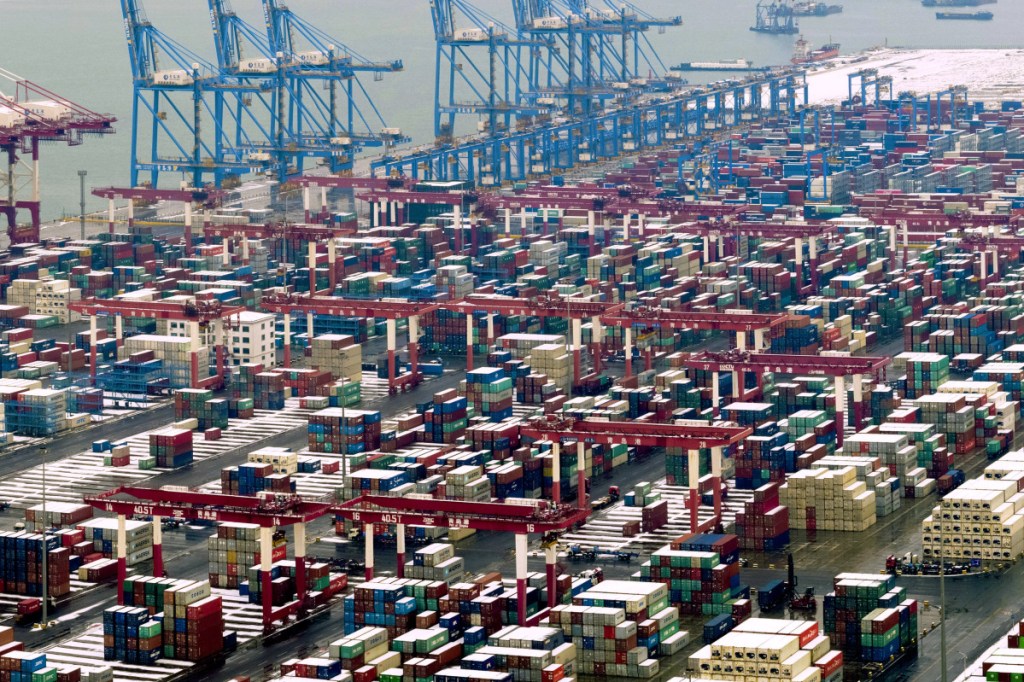 In this Feb. 14 photo, trucks move around containers stored at a port in Qingdao in east China's Shandong province. President Trump said Sunday that he will extend a deadline to escalate tariffs on Chinese imports, citing "substantial progress" in weekend talks between the two countries.
(Chinatopix via AP)