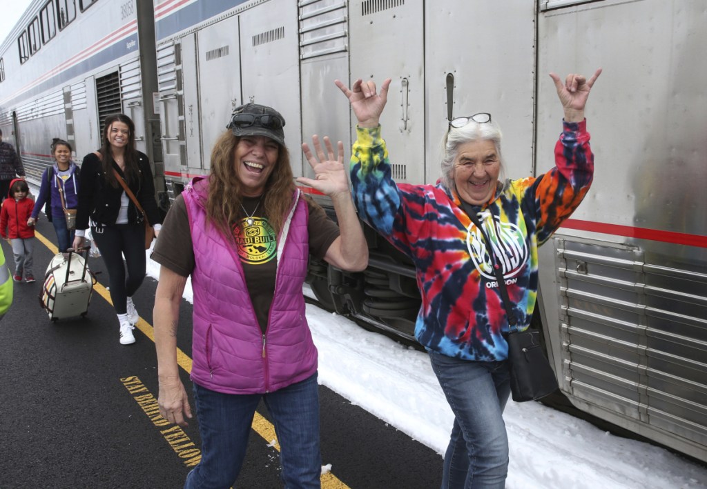 Patricia Bailey, center, and Annette Saba, right, celebrate as they disembark an Amtrak passenger train in Eugene, Ore. Tuesday. The train traveling from Seattle to Los Angeles with 183 passengers got stranded in the snowy mountains of Oregon for 36 hours.  (AP Photo/Chris Pietsch)