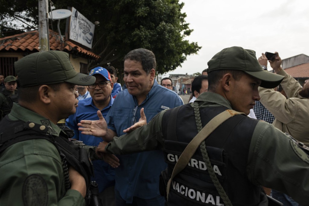 Opposition politicians and staffers talk with the Venezuelan National Guard about getting access through a control point the guard had set up in the streets of Capacho, Venezuela, on Saturday. They were not successful and had to find another way to the border. The opposition caravan was en route to the border with Colombia in an effort to bring aid into the country.