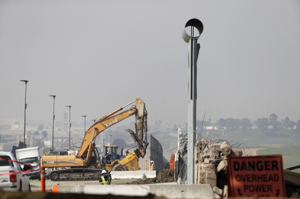 Crews work to demolish wall prototypes at the border between Tijuana, Mexico, and San Diego on Wednesday in San Diego.