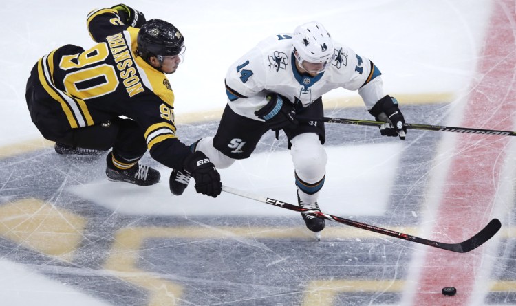 Boston winger Marcus Johansson tries to strip the puck from the Sharks' Gustav Nyquist during Johansson's Bruins debut Tuesday, a 4-1 victory.