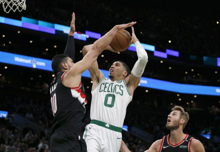 Boston's Jayson Tatum shoots as Portland's Enes Kanter defends during the first half Wednesday night in Boston.