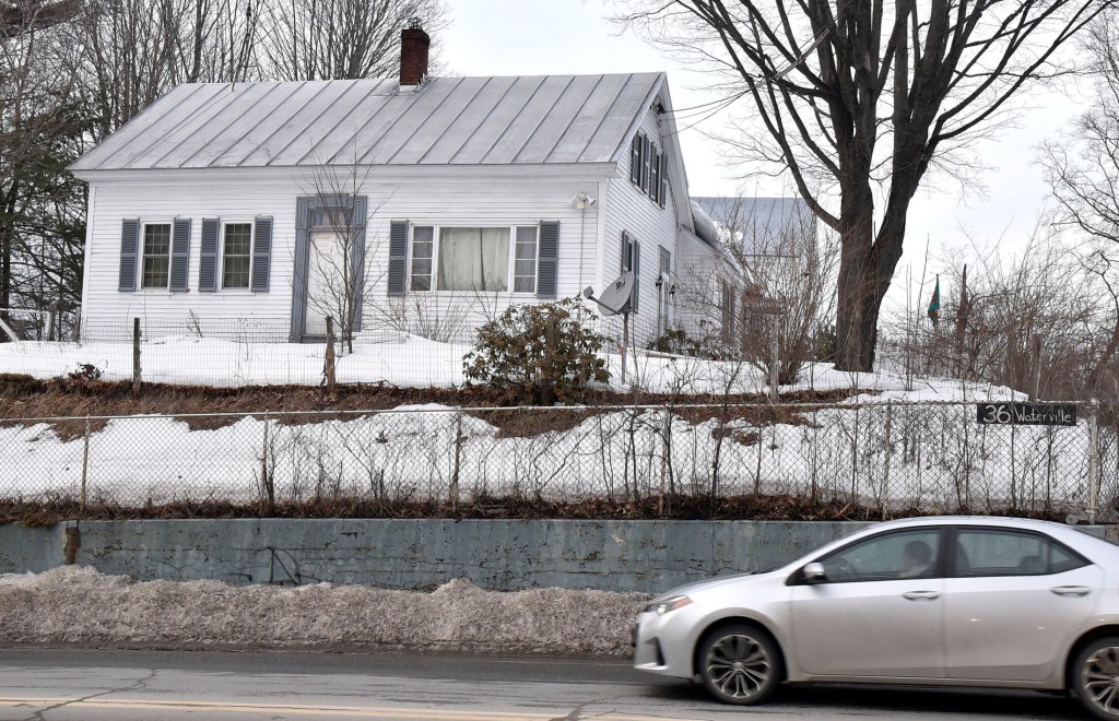 A motorist passes the home at 36 Waterville Road in Skowhegan, where police and state animal welfare agents searched as part of an animal abuse investigation on Wednesday.