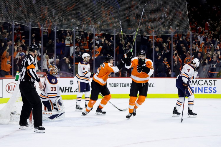 Philadelphia Flyers' James van Riemsdyk (25) and Travis Sanheim (6) celebrate past Edmonton Oilers' Kris Russell (4), Ty Rattie (8) and Cam Talbot (33) after Nolan Patrick scored the game-winning goal during overtime Saturday in Philadelphia. Philadelphia won 5-4.