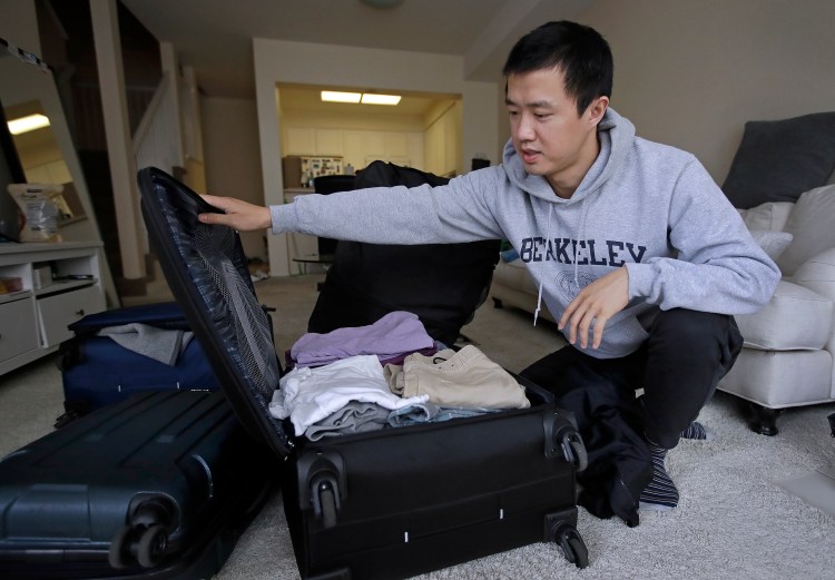 In this Monday, Feb. 4, 2019, photo, Leo Wang packs a suitcase at his home in San Jose, Calif. Wang has found himself trapped in an obstacle course regarding H-1B work visas for foreigners. His visa denied and his days in the United States numbered, Wang is looking for work outside the country. “I still believe in the American dream,” he says. “It’s just that I personally have to pursue it somewhere else.” 