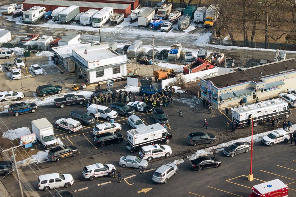 First responders and emergency vehicles gather near the scene of the shooting at an industrial park in Aurora, Ill., on Friday.