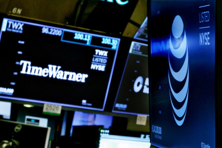 In this June 13, 2018, file photo, the logos for Time Warner and AT&T appear above alternate trading posts on the floor of the New York Stock Exchange.  A federal appeals court has blessed AT&T's takeover of Time Warner, Tuesday, Feb. 26, 2019, defeating the Trump administration by affirming that the $81 billion merger won't harm consumers or competition in the booming pay TV market. 