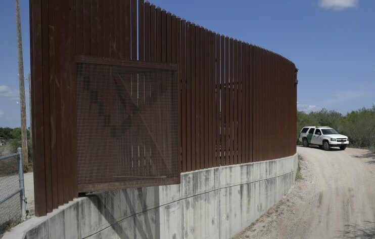 A U.S. Customs and Border Patrol vehicle passes along a section of border levee wall in Hidalgo, Texas on Aug. 11, 2017. 