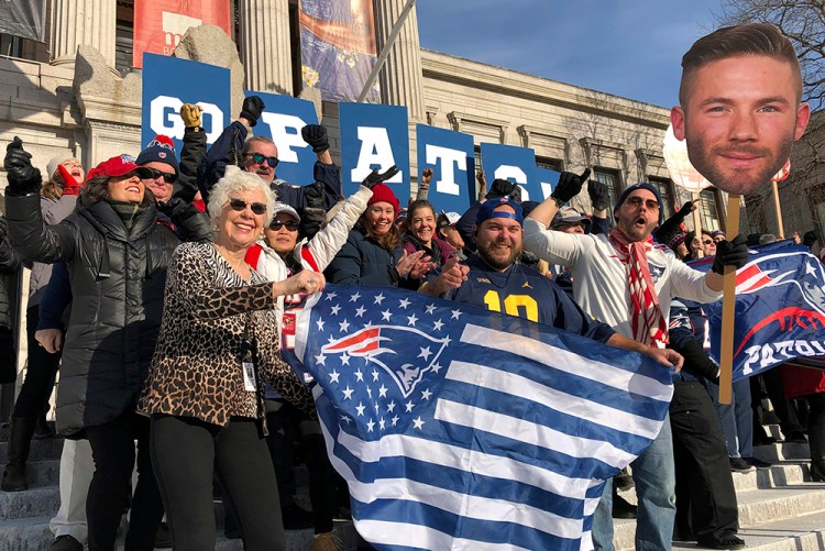 Workers at Boston’s Museum of Fine Arts rally outside in New England Patriots garb on Friday. The museum and Los Angeles’ J. Paul Getty Museum are trading a little trash talk ahead of the Super Bowl between the Patriots and the Rams. 