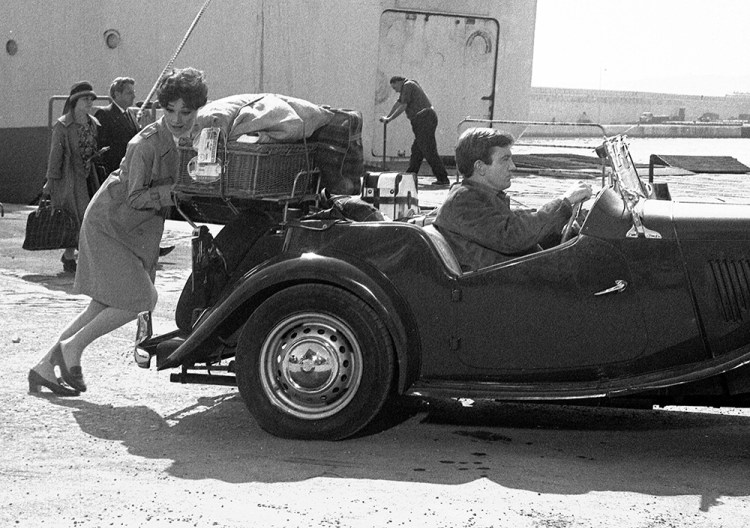British actor Albert Finney, stays at the wheel of his sportscar, while  Audrey Hepburn pushes, during a scene from the film "Two for the road" in 1966. 