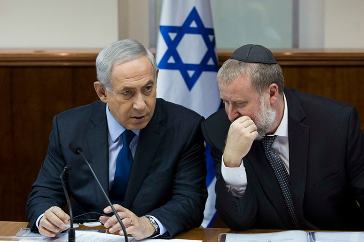In 2015 Israel's Prime Minister Benjamin Netanyahu, left, speaks with then Cabinet Secretary Avichai Mandelblit during the weekly cabinet meeting in Jerusalem. Now attorney general, Avichai Mandelblit  has recommended indicting Netanyahu.