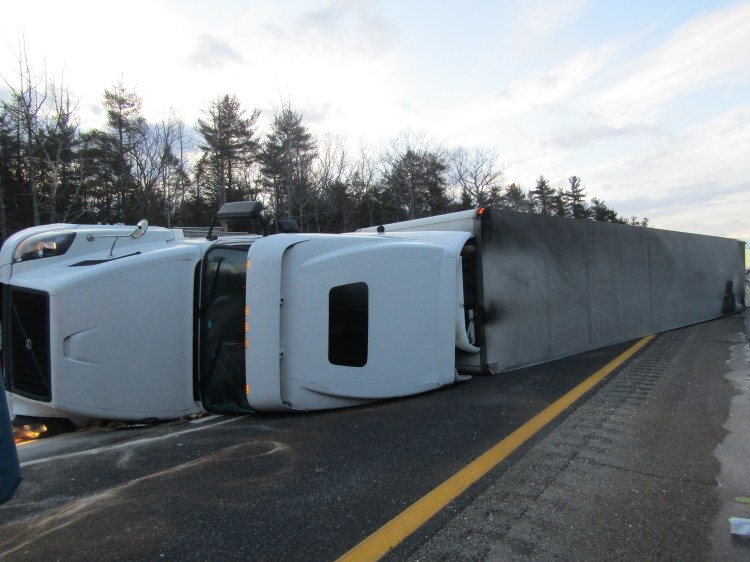 This overturned tractor trailer was slowing traffic on the Maine Turnpike on Monday. Police diverted motorists through the breakdown lane.
