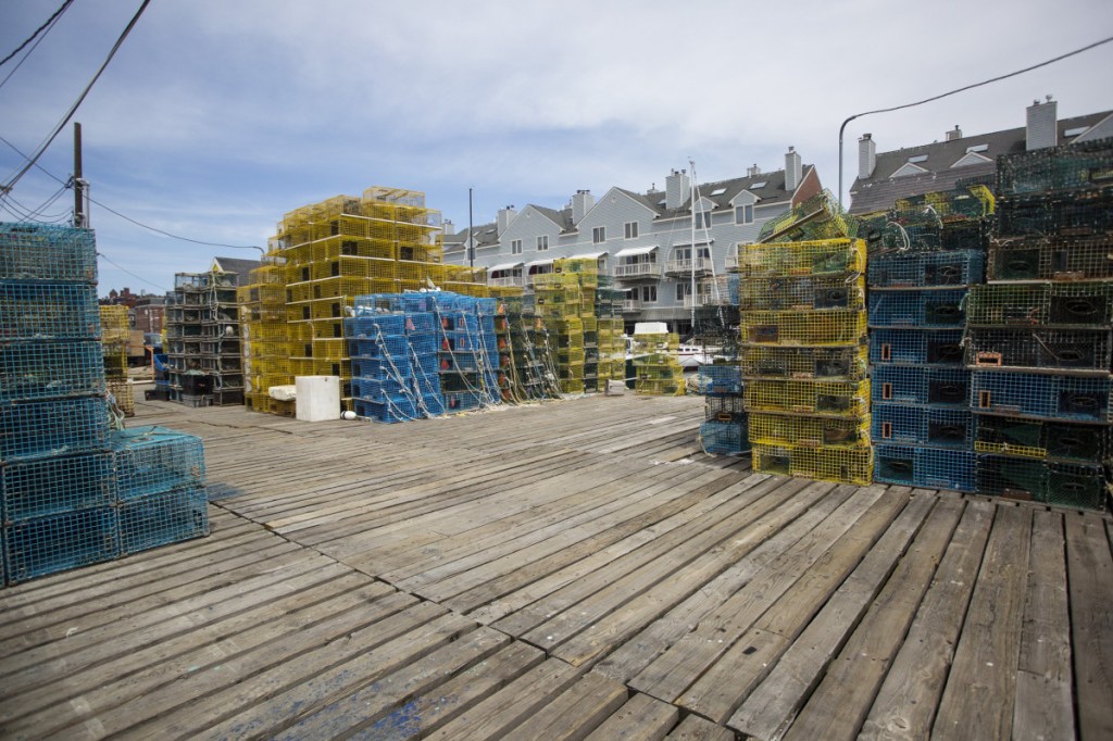 Lobster traps are piled high on Widgery Wharf in Portland. Last year saw an uptick in Maine lobster landings, both in size and value, according to data released Friday at the Maine Fishermen's Forum.